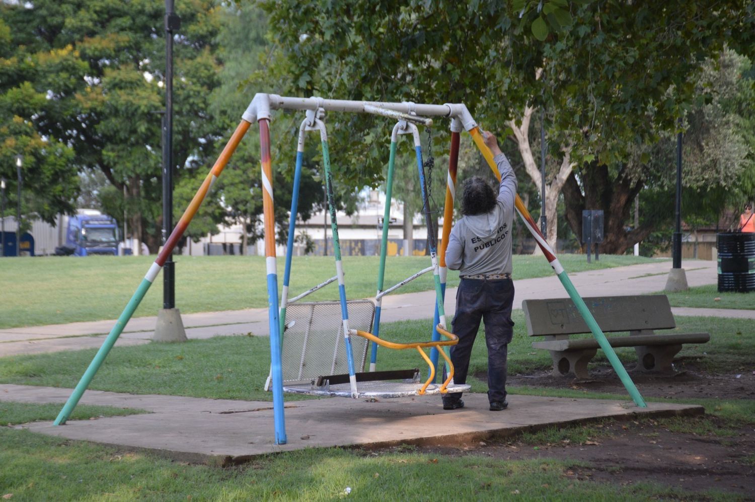 Personal municipal realizando trabajo de pintura en la plaza.