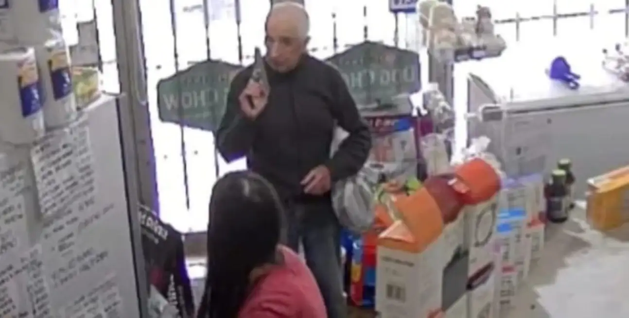 El momento en que el hombre exhibe el arma de fuego y amenaza a la empleada.