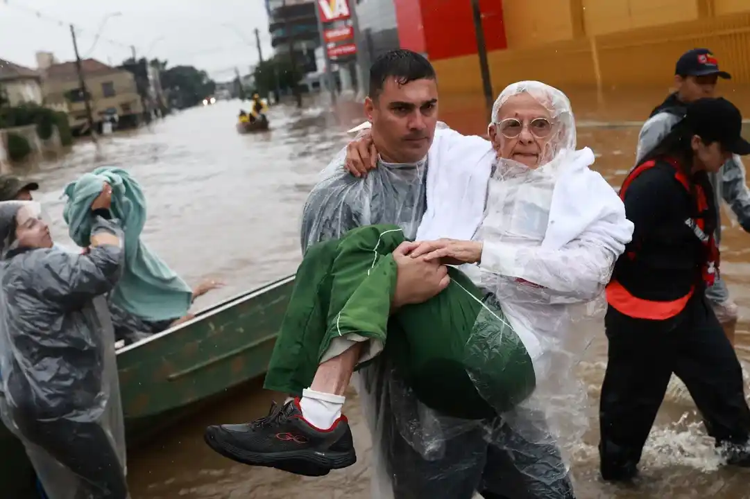 Un voluntario lleva a un hombre, que ha sido evacuado de una zona inundada en Porto Alegre, estado de Rio Grande do Sul, Brasil 10 de mayo 2024