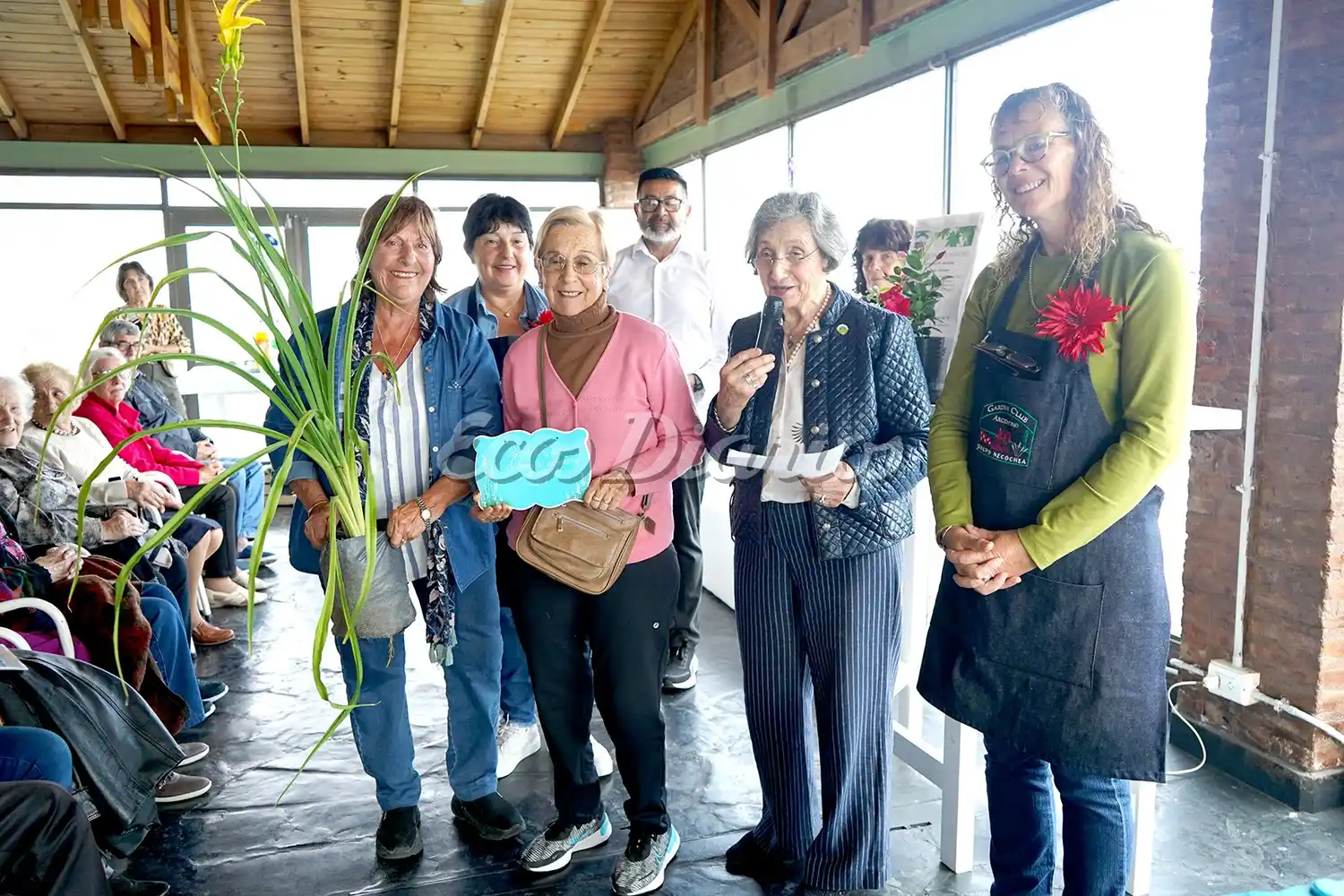 Integrantes de la entidad organizadora premian a una de las ganadoras