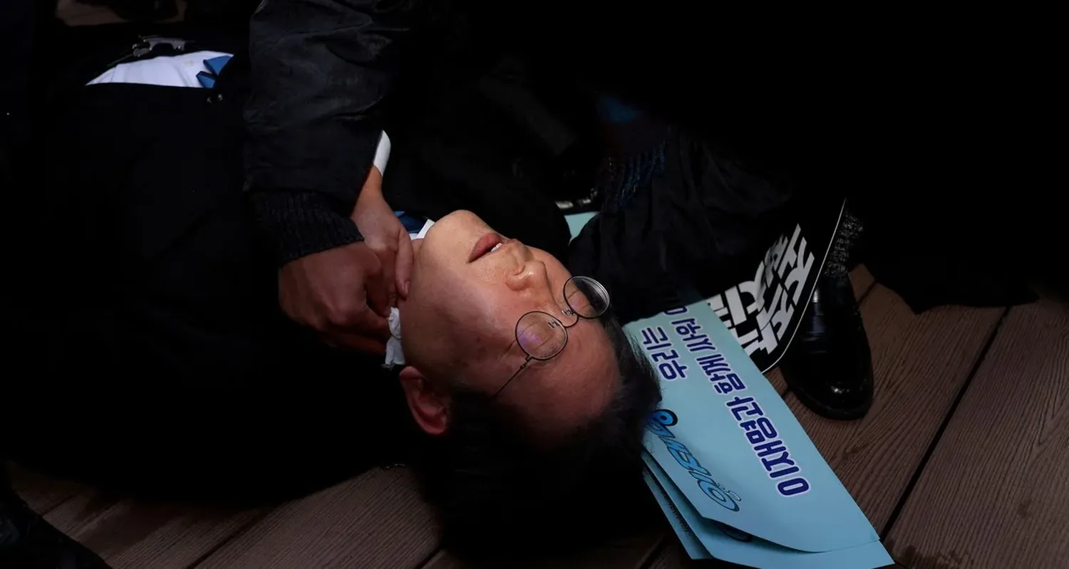 Lee Jae-myung, líder de la oposición en Corea del Sur, tendido en el suelo tras recibir una puñalada en el cuello. Crédito: Yonhap