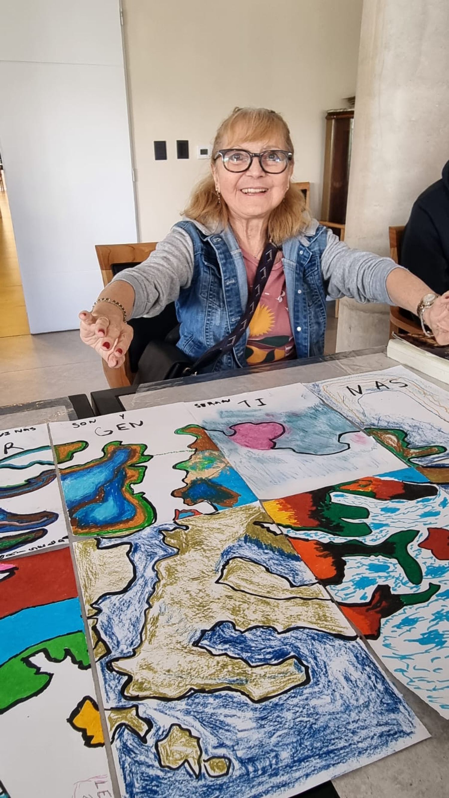 Una residente de Galatea muestra con orgullo su participación en un taller de expresión plástica, parte de las actividades que estimulan la creatividad y el sentido de logro.