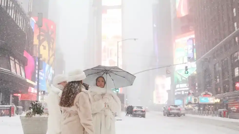 Un grupo de personas cruzando la calle en Times Square durante la tormenta de invierno. (Foto AP: Heather Khalifa)
