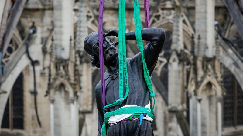 Una grúa eleva una estatua de Santo Tomás, la última de las 16 estatuas gigantes de apóstoles revestidas de cobre en colocarse. / Foto Por AFP