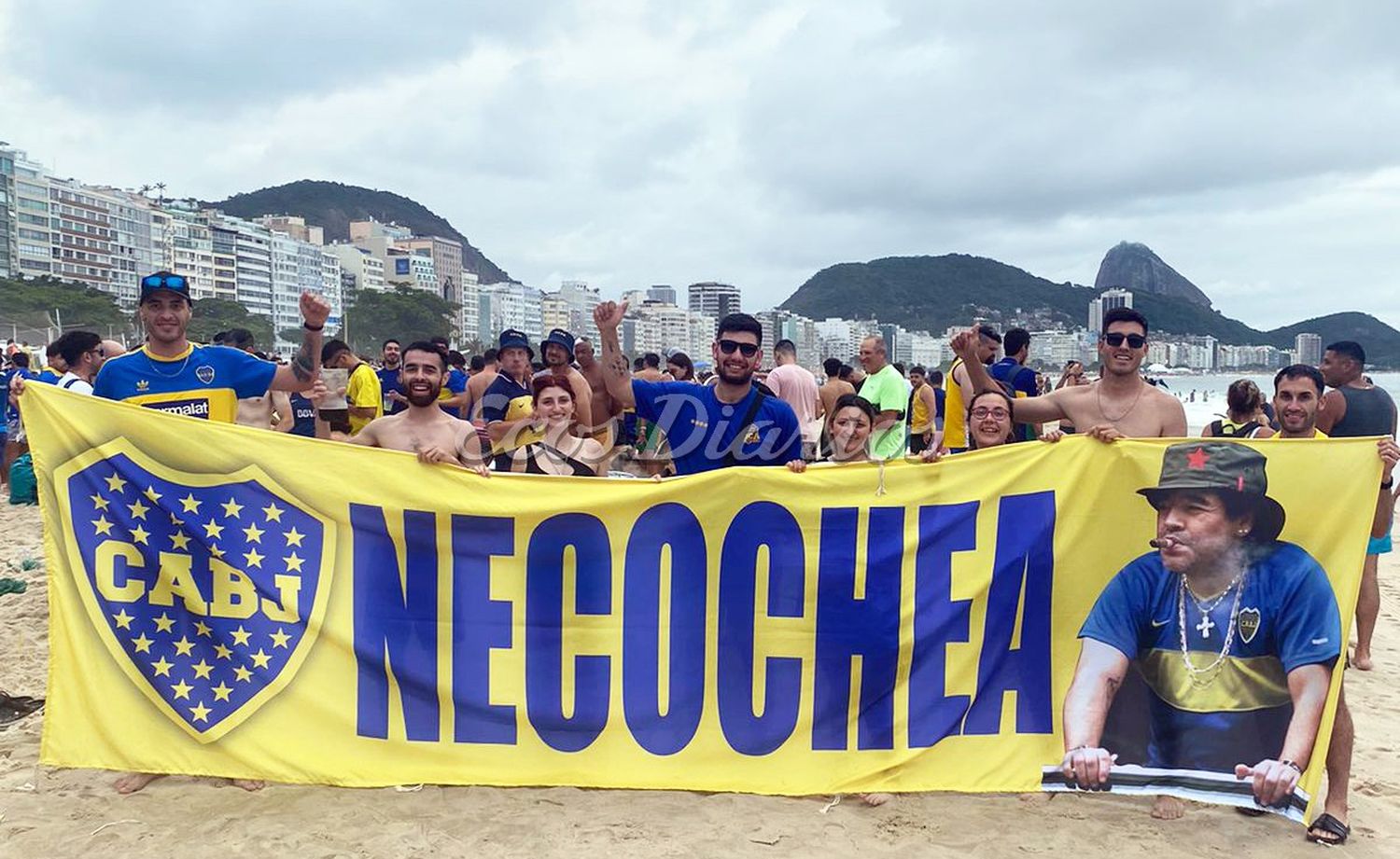 En la playa de Copacabana. Un grupo de necochenses despliega una inmensa bandera