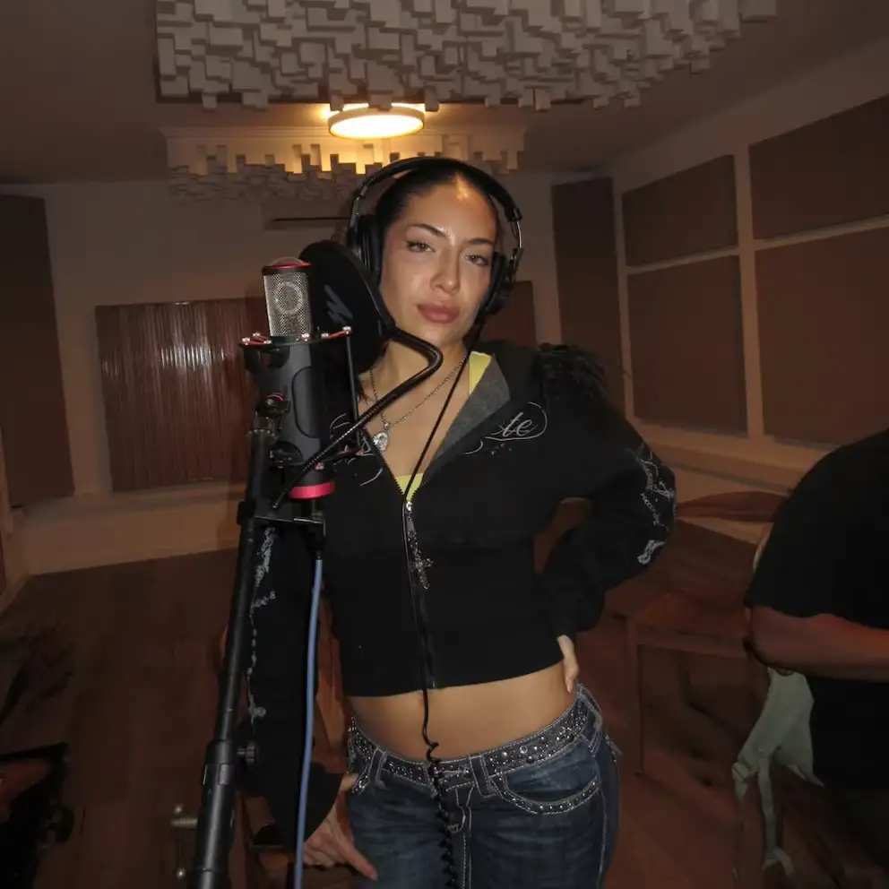 Ailín sonríe mientras graba en un estudio, marcando el inicio de su propia carrera musical