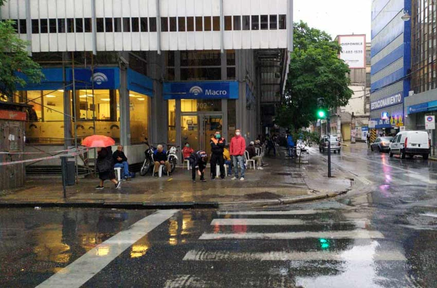 Jubilados bajo la lluvia en la puerta de los bancos que además atenderán a clientes con turnos