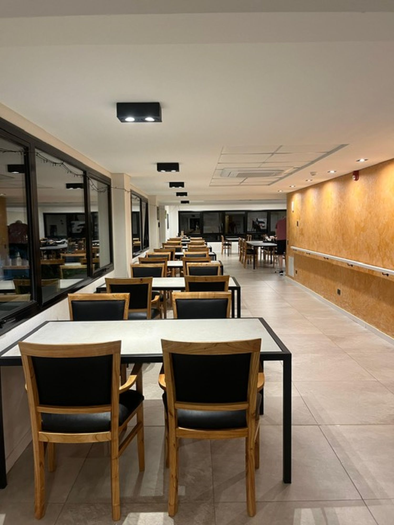 El comedor principal, con grandes ventanales, es también un espacio de encuentro para residentes y familiares.