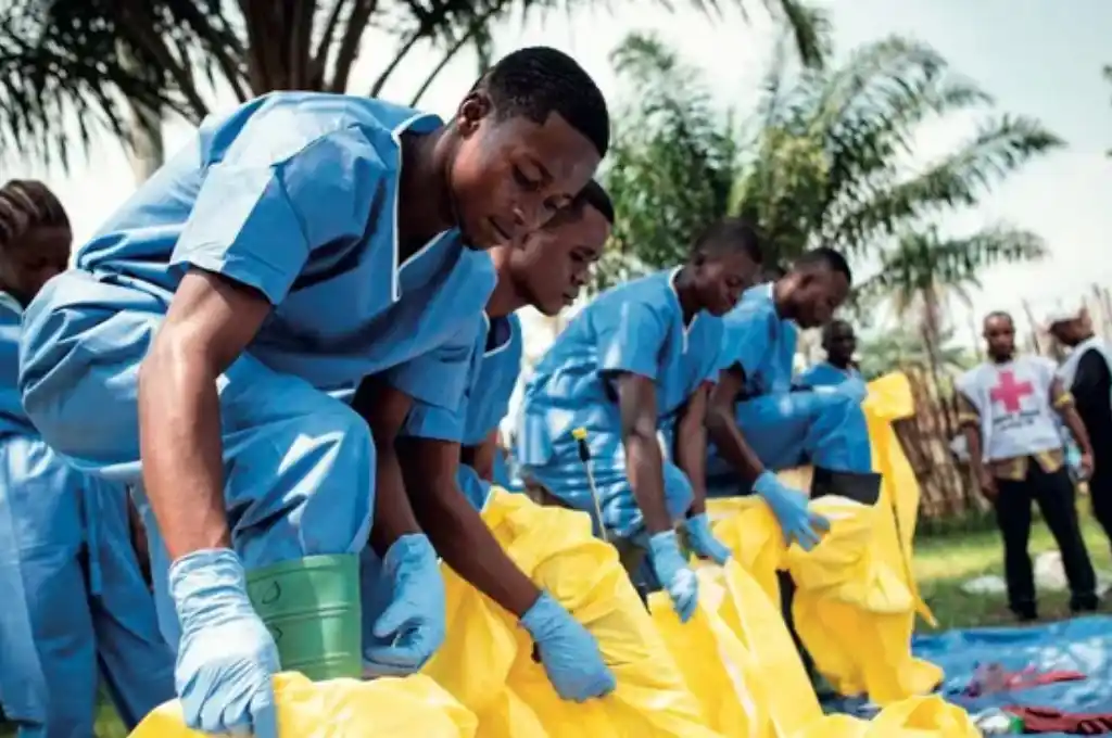 Trabajadores médicos con trajes protectores comienzan su turno en un centro de tratamiento del ébola