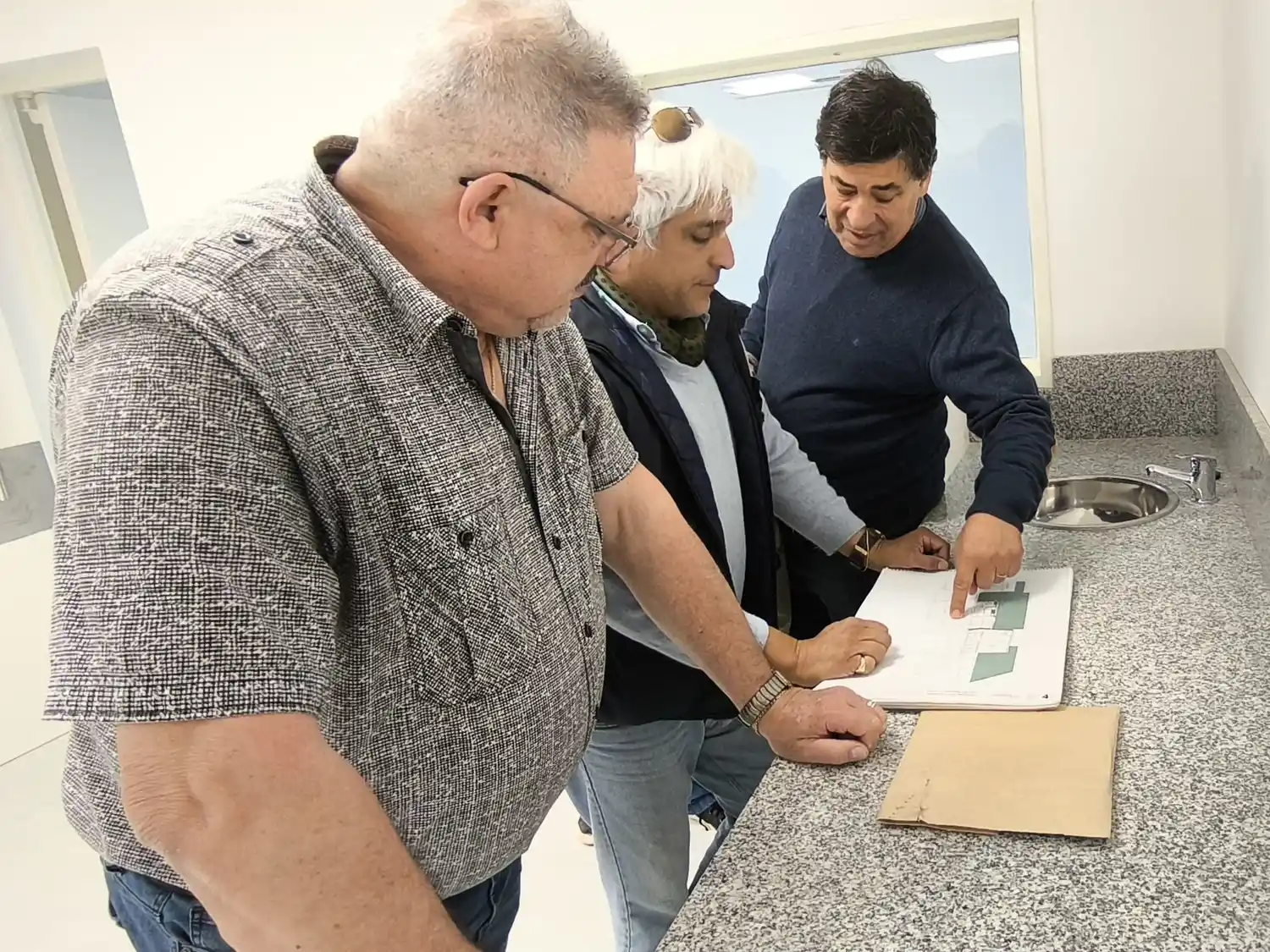 El profesional que lleva adelante la obra le indica los pasos que siguen a miembros de la Sociedad Española