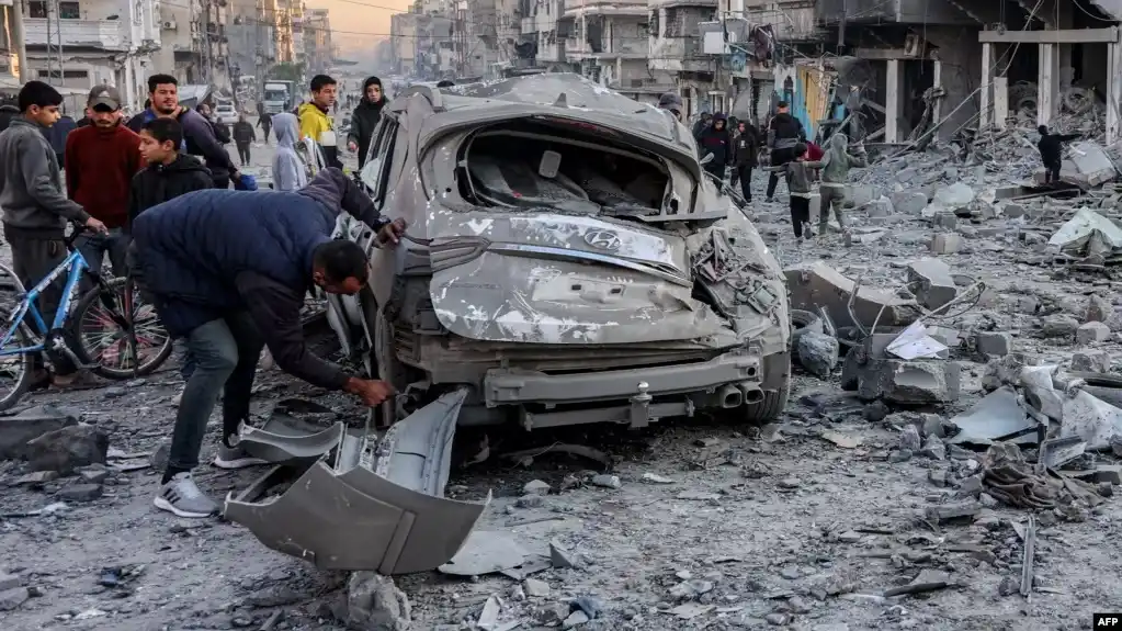 Un hombre inspecciona un vehículo destruido durante un ataque en la calle Jalaa de Gaza