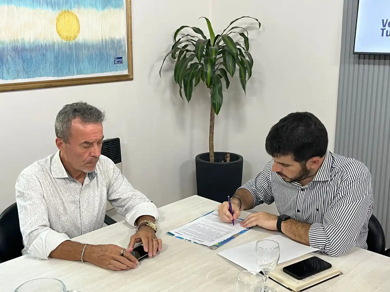 El intendente Leonel Chiarella (derecha) firmando el convenio junto a Carlos Torres (izquierda).