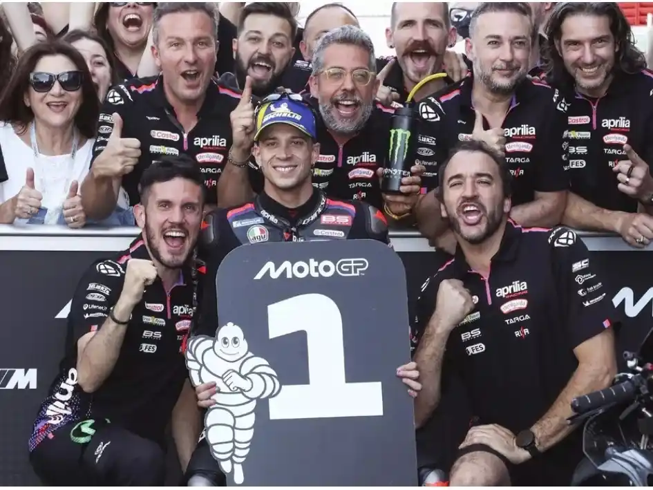 Bezzechi celebrando el triunfo junto al equipo Aprilia. Foto: Moto GP