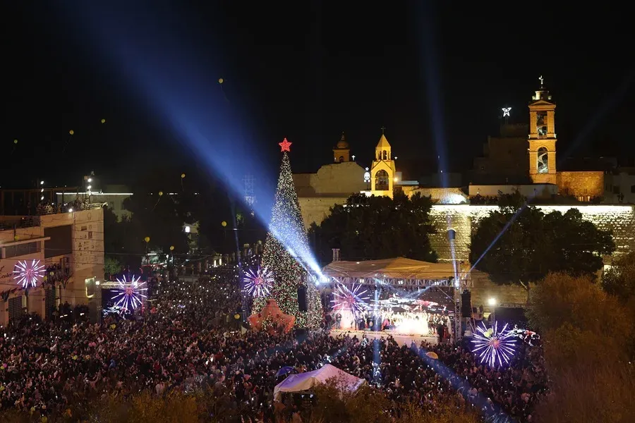 Encendido del árbol de Navidad en la plaza del Pesebre, junto a la Iglesia de la Natividad al fondo, en la ciudad cisjordana de Belén. EFE