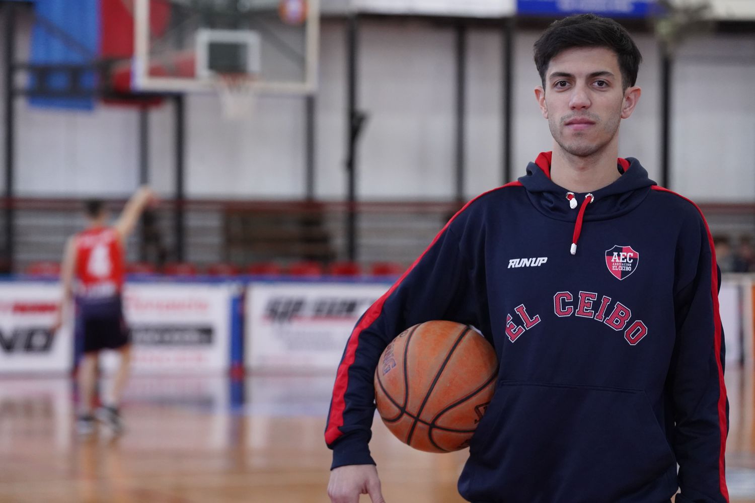 Lautaro Oitana, entenador de El Ceibo, posando con una pelota de básquet