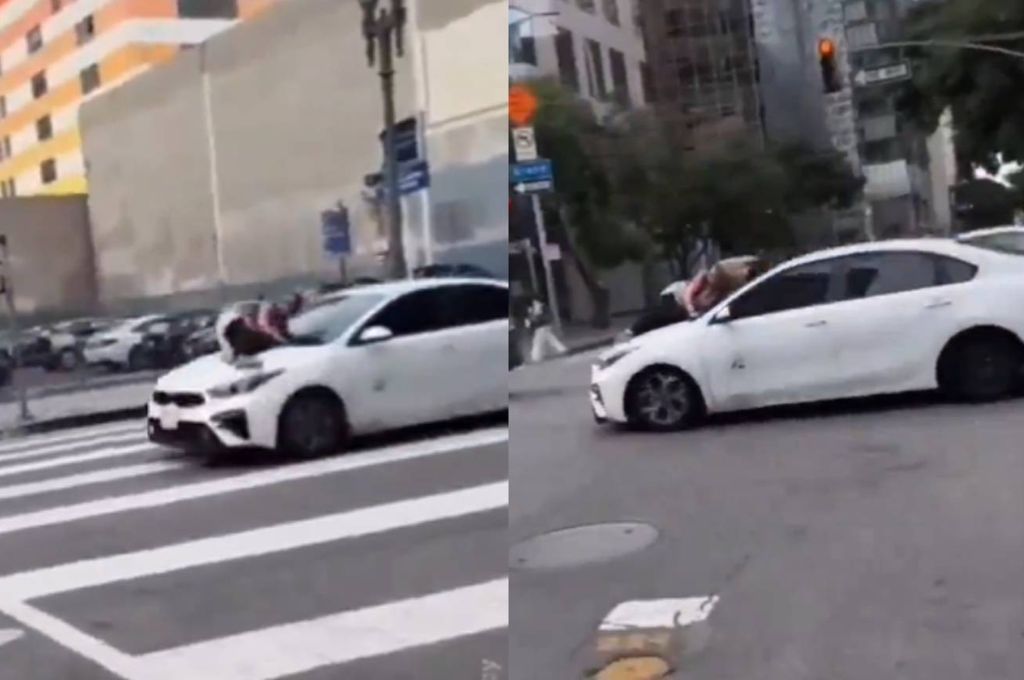 La mujer ferrada al capó de un auto