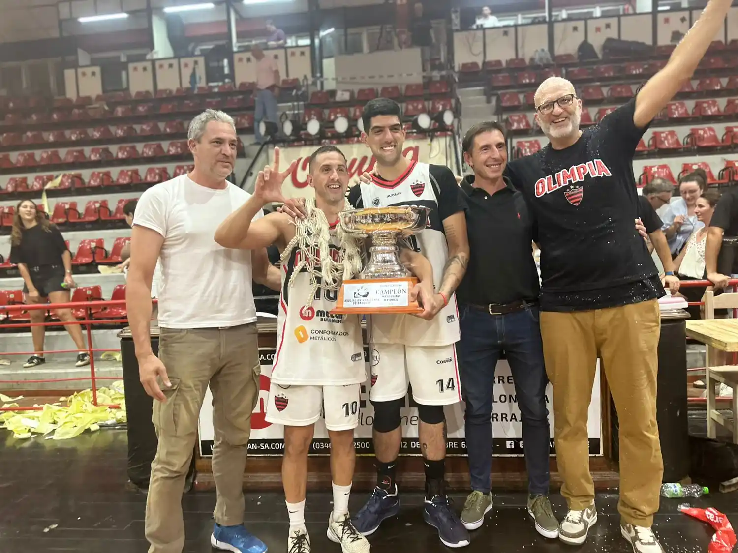 Damián Palacios y Manuel García, los emblemas de Olimpia, recibiendo junto al DT Andrés Rodríguez la Copa de campeones entregada por Diego Tomé, presidente de la ABB