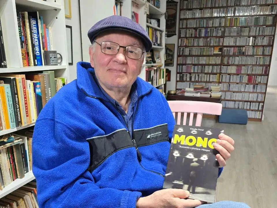 Carlos Inzillo, en su universo de libros y discos, sostiene un ejemplar de "Mono", dedicado al pianista Enrique Villegas.