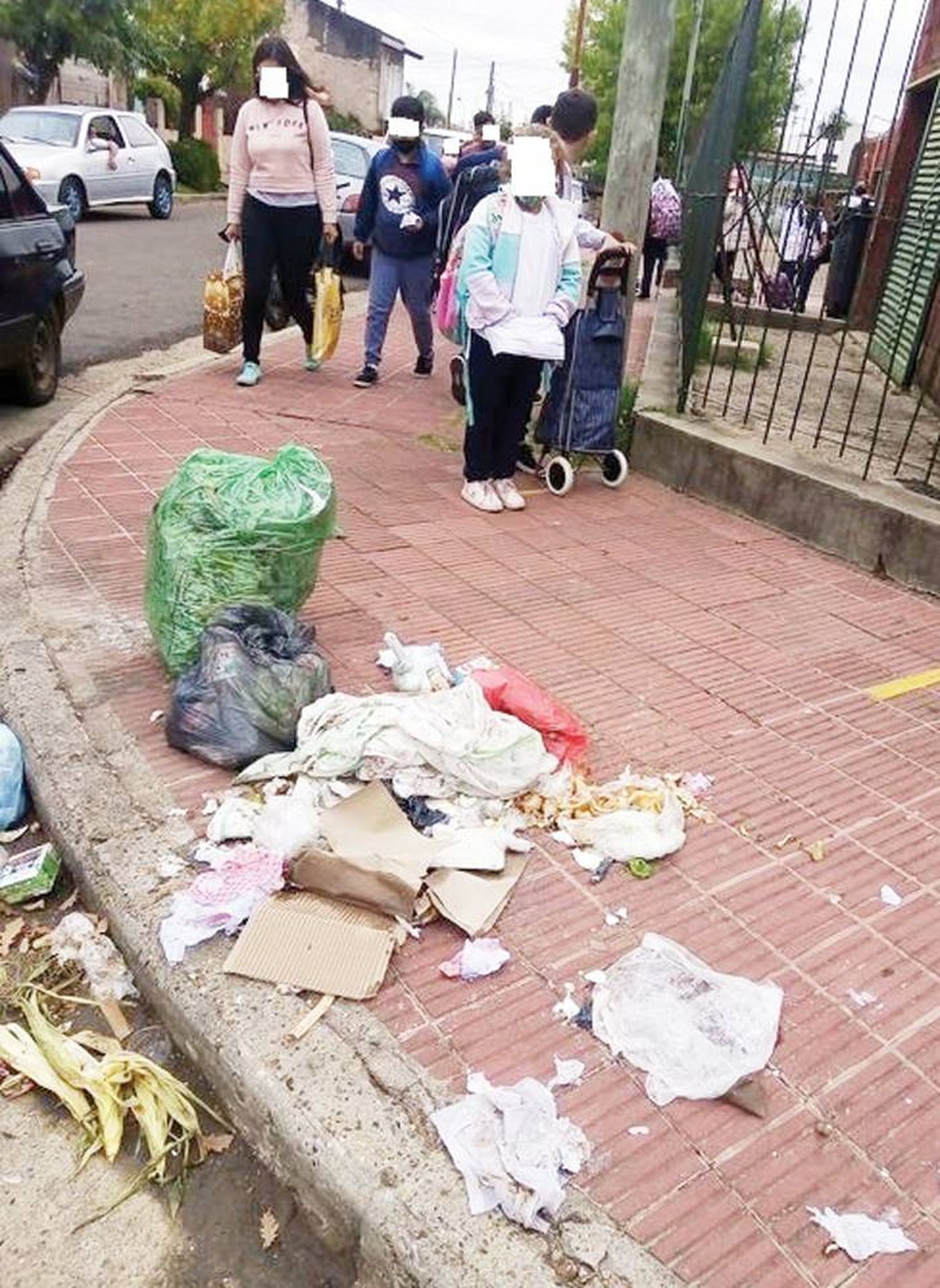 Vecinos sucios: Los niños esquivan la suciedad  cuando salen de la escuela