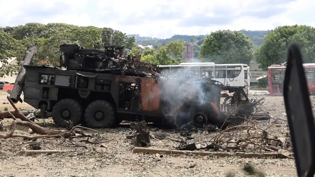 Un vehículo militar incinerado luego de ser impactado en la Base Aérea Generalísimo Francisco de Miranda, también conocida como La Carlota este sábado, en Caracas (Venezuela)