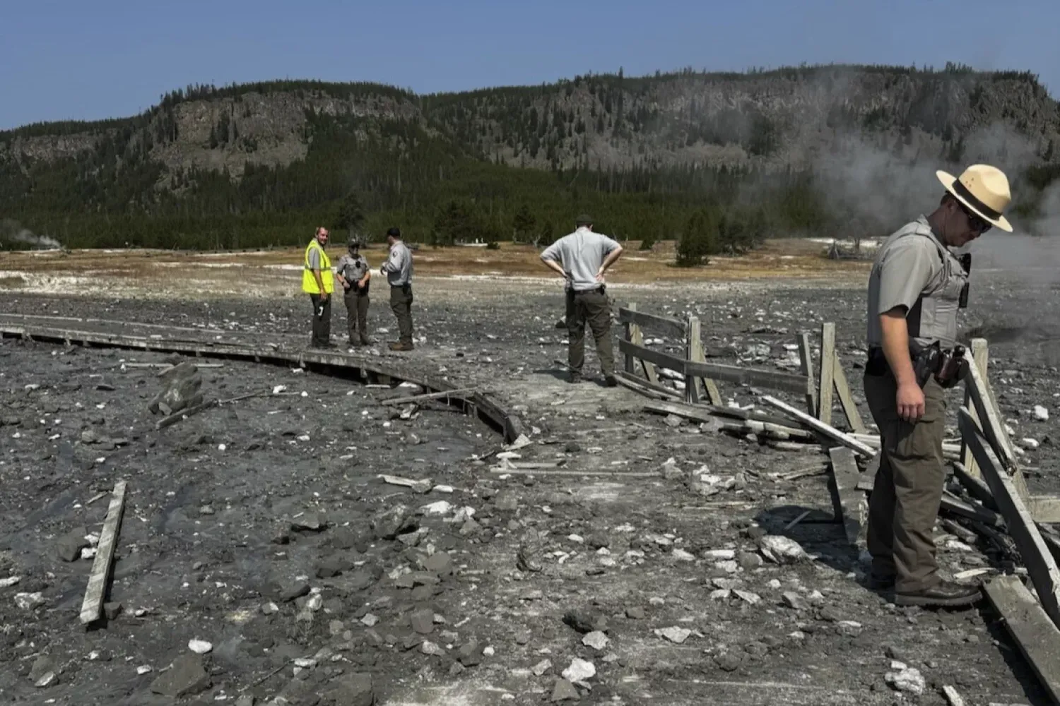 In this photo released by the National Park Service, park staff assess the damage to Biscuit Basin boardwalks after a hydrothermal explosion at Biscuit Basin in Yellowstone National Park, Wyo., on Tuesday.