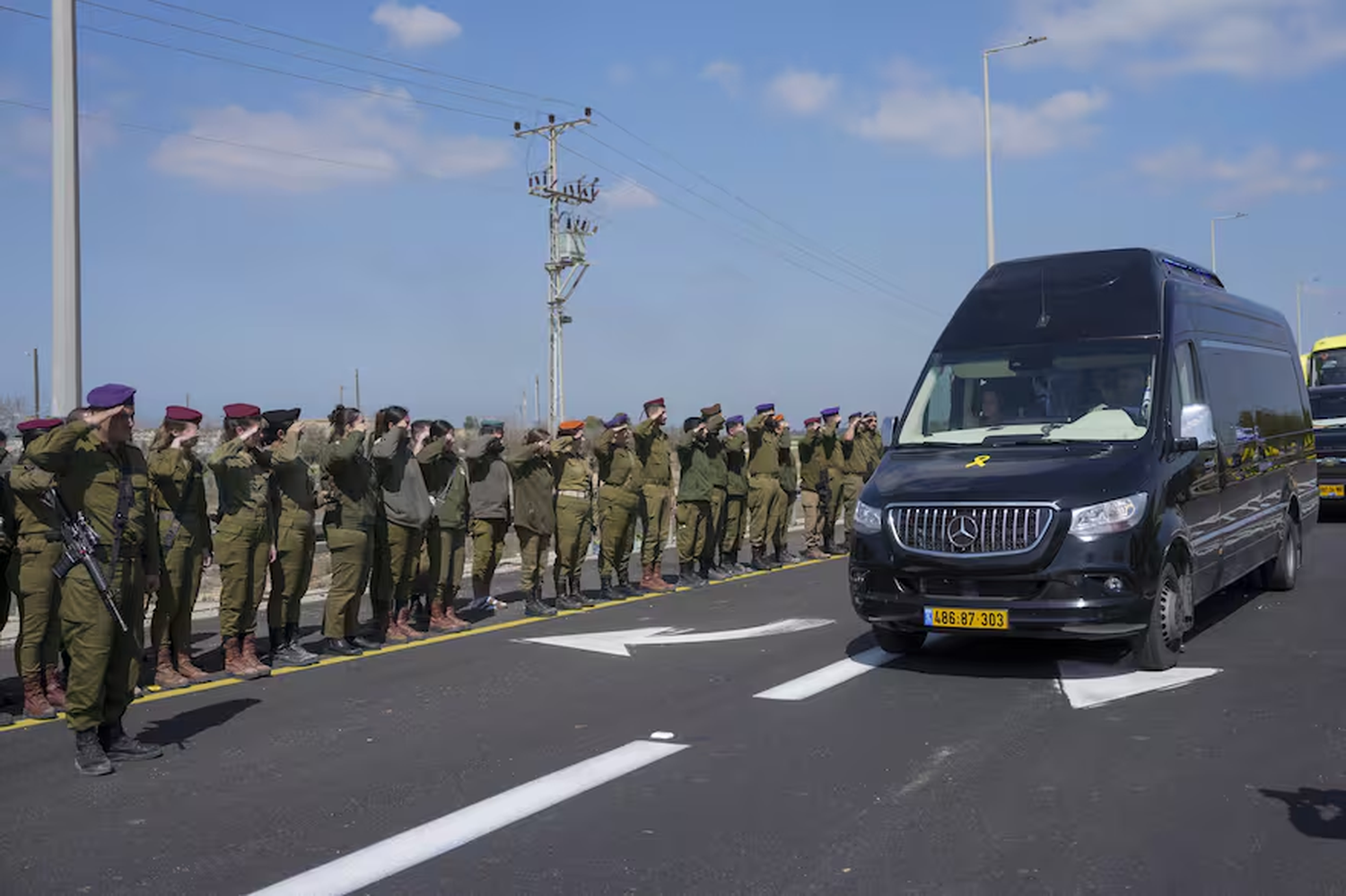 Soldados israelíes rinden homenaje mientras el convoy que transporta los féretros de los rehenes asesinados Shiri Bibas y sus dos hijos, Ariel y Kfir, pasa cerca del Kibutz Nir Oz, en el sur de Israel,