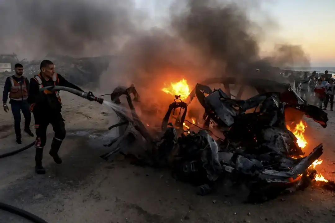 Imagen de archivo de rescatistas mientras apagan un auto tras un ataque aéreo.