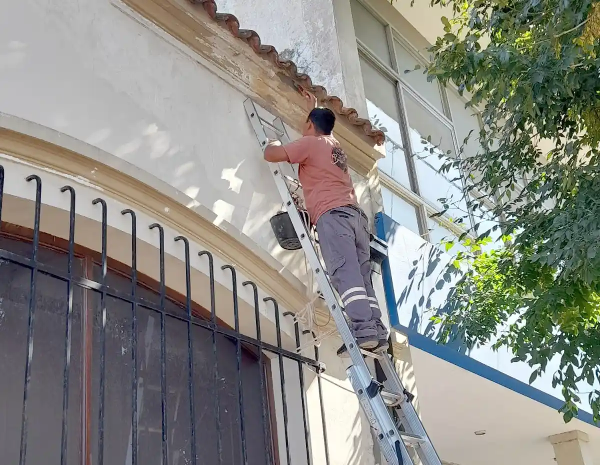 Un operario. Pinta el frente del edificio de calle 54