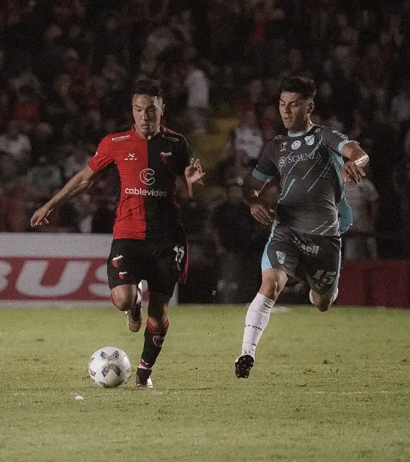 Lago lleva la pelota, perseguido por Richarte.