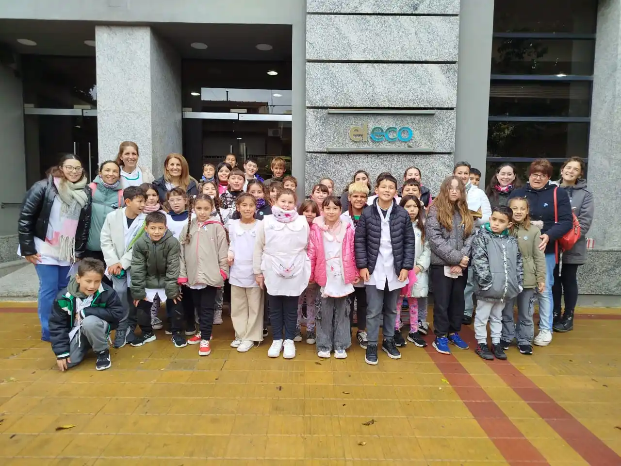 Docentes, padres y alumnos de la Escuela Primaria 32 hicieron un alto en El Eco y continuaron repartiendo escarapelas.
