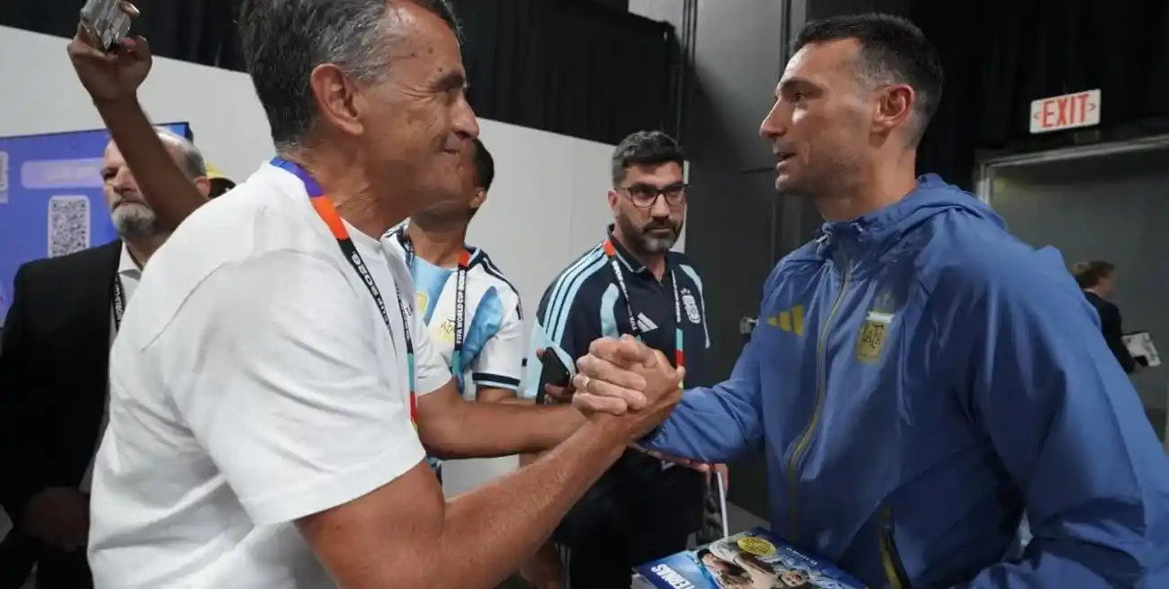 Lionel Scaloni, el DT campeón del mundo, recibe el libro Lágrimas Eternas de manos de su autor, Enrique Cruz, quien cubrió el Mundial de Qatar para El Litoral.