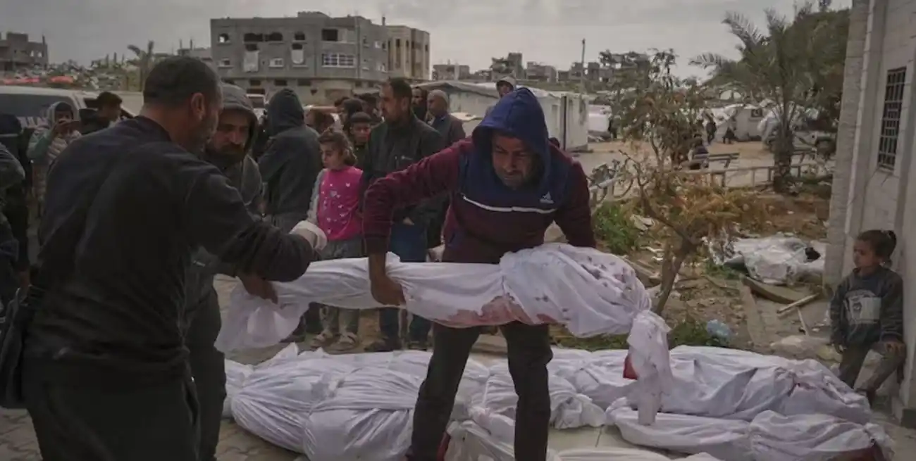 Palestinos preparan los cuerpos para el entierro de víctimas de un bombardeo.