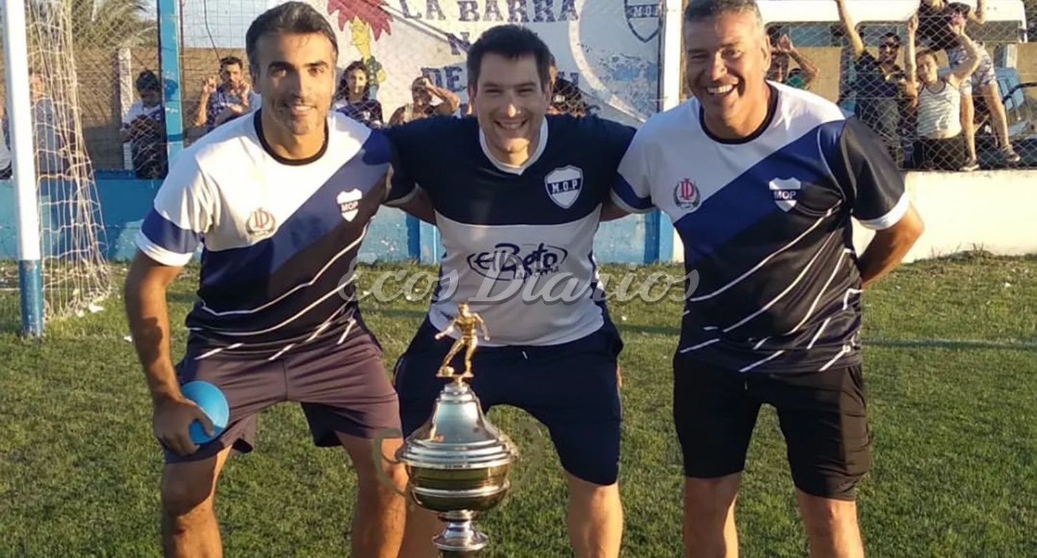 El cuerpo técnico de Ministerio de izq. a der. Ariel Tristán, Juan David Trippe y Gustavo Andraca, posan con el trofeo de campeón