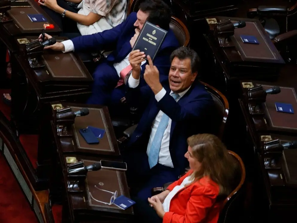 Manes, en el momento en el que le muestra la Constitución al presidente Milei