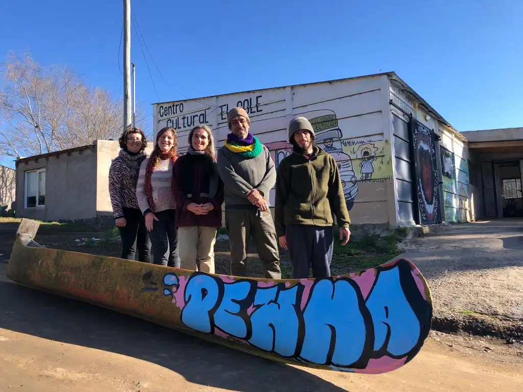 Parte del grupo, junto a la canoa Pewma, intervenida por el joven artista Yaro, oriundo del barrio.