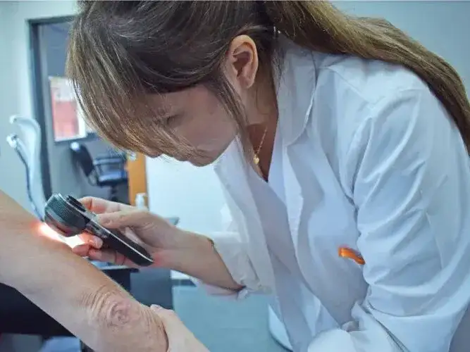 Una profesional de la salud realiza un examen dermatológico utilizando un dermatoscopio para la detección temprana de lesiones en la piel, reforzando las acciones de prevención y tratamiento de la lepra en los centros médicos de Formosa.