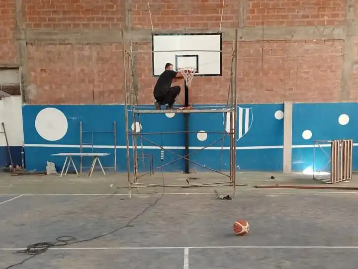 Agricultores trabaja para acondicionar su cancha de básquet.