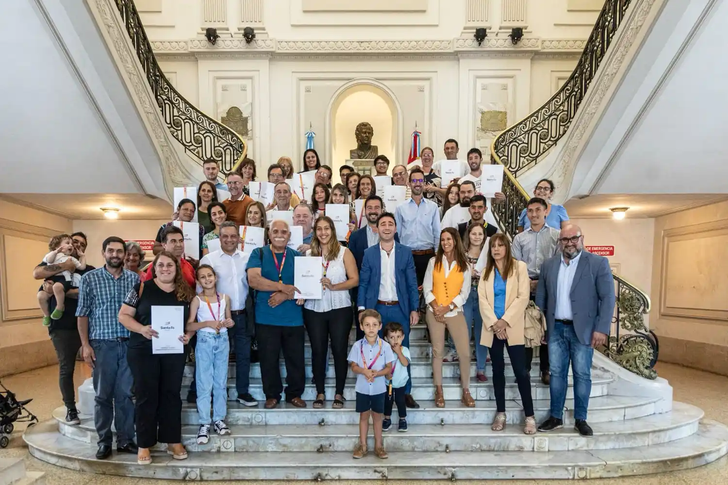 Familias felices recibiendo las escrituras de sus viviendas.