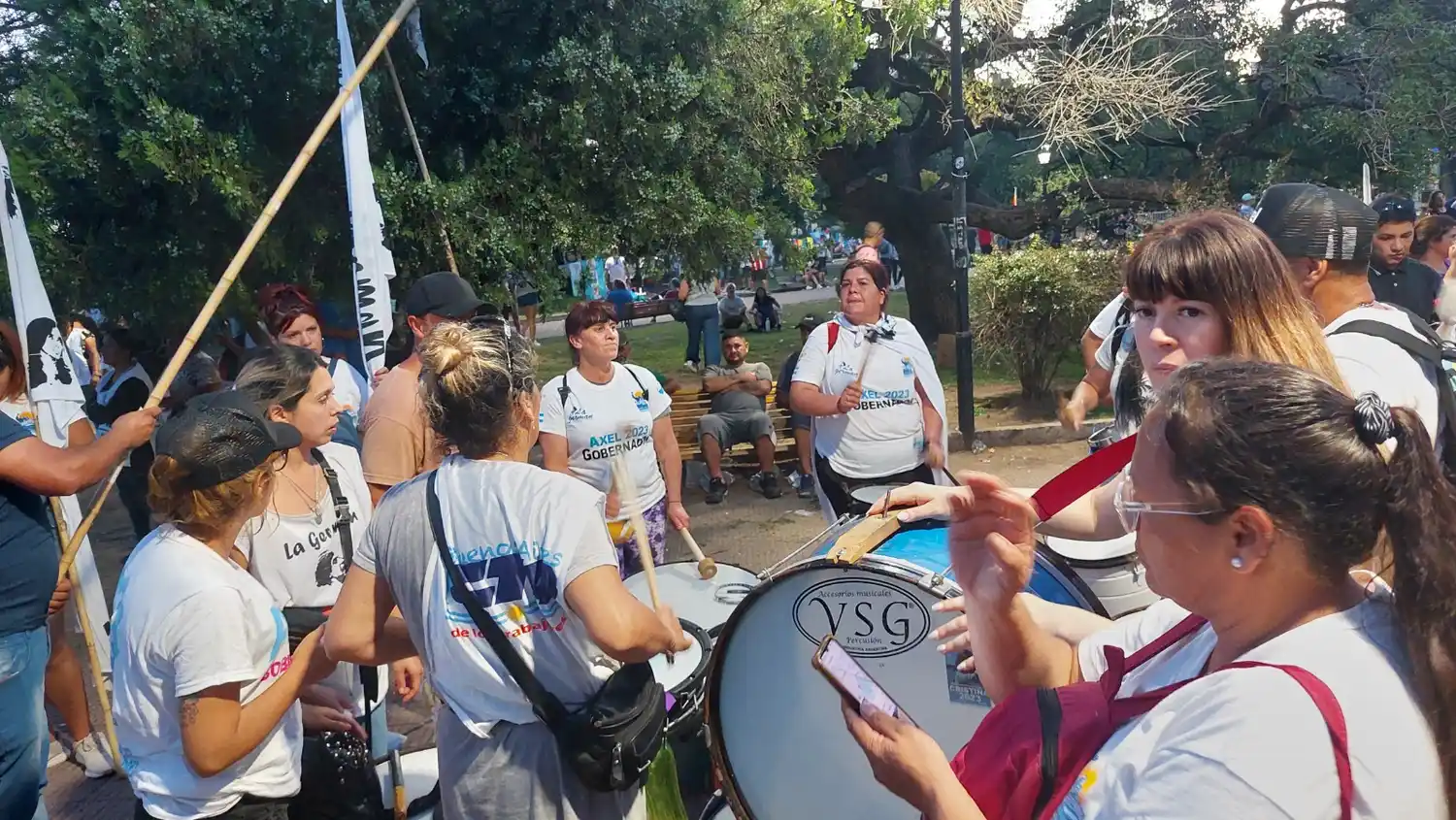Al costado de las vallas suenan bombos y flamean banderas.