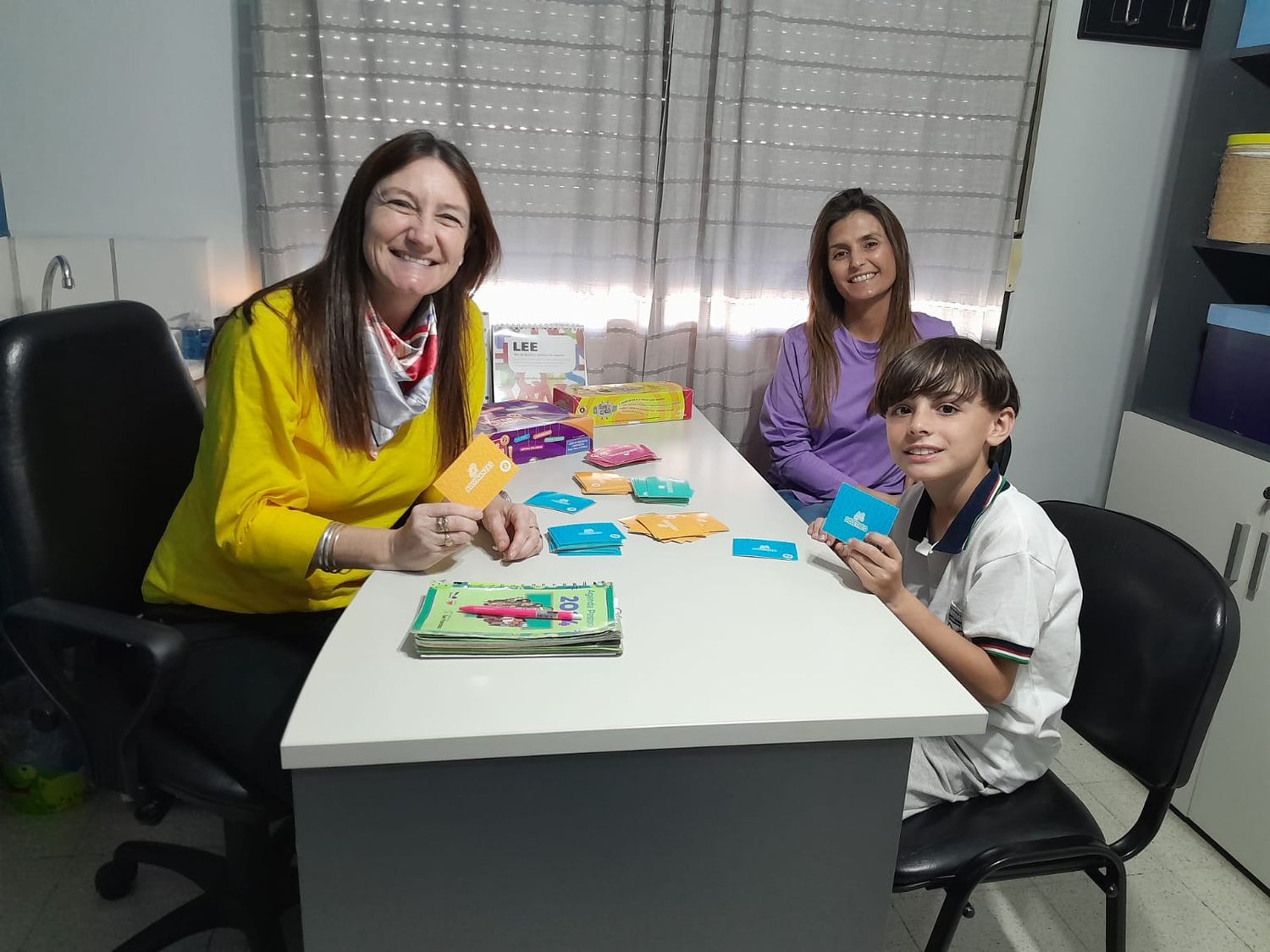 La licenciada Busato y José aprendiendo con un juego de mesa. La mamá Vanina confía en la guía de la psicopedagogía