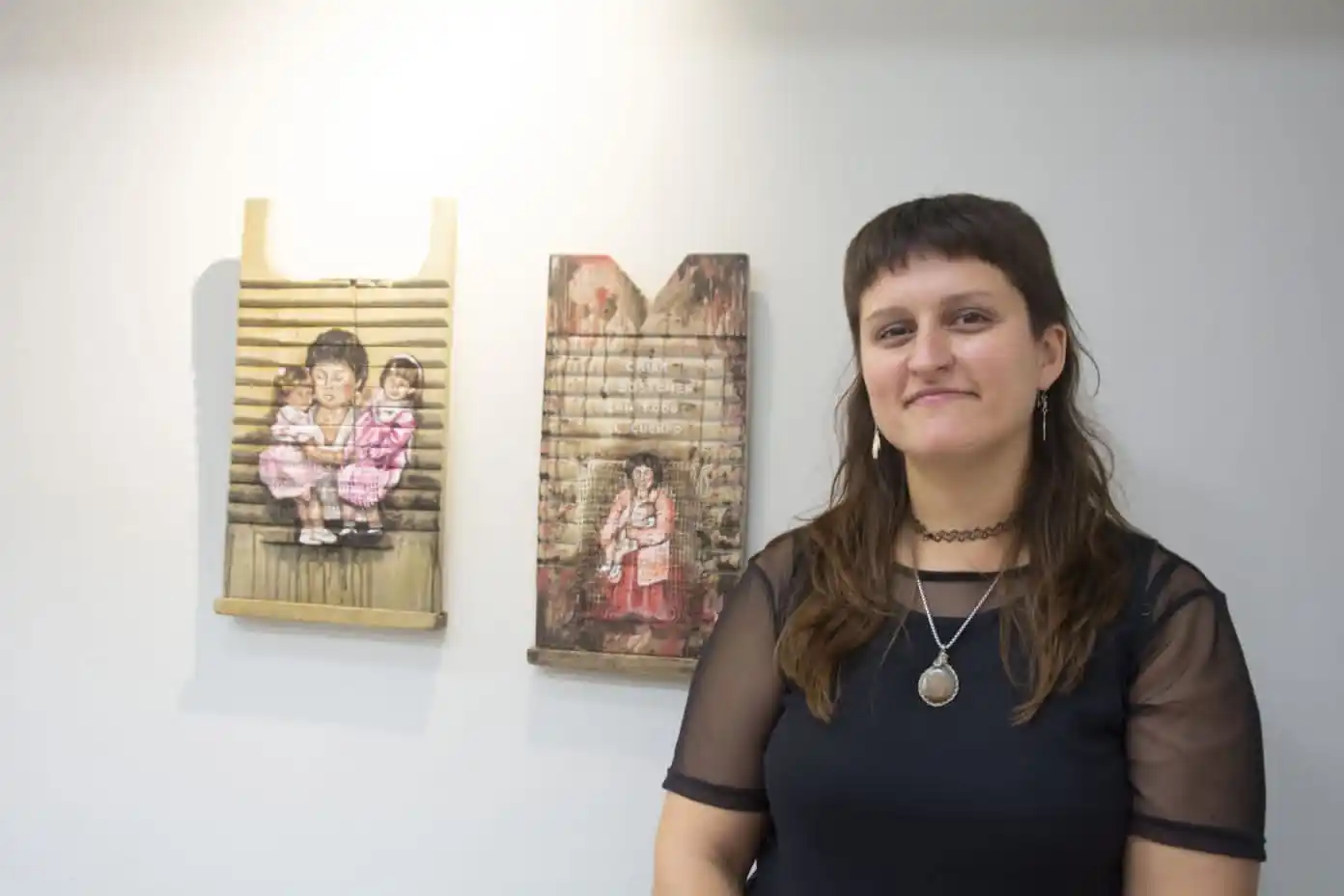 Malu López, junto a dos de sus objetos intervenidos que pueden verse en "Un puntal invisible"