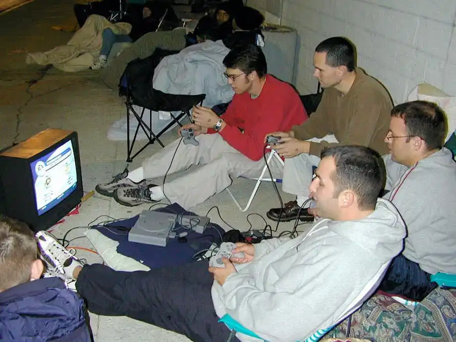 Un grupo de amigos jugando a la PlayStation 1 a las afueras de un Best Buy a la espera de que pongan a la venta la PlayStation 2 en octubre del 2000.