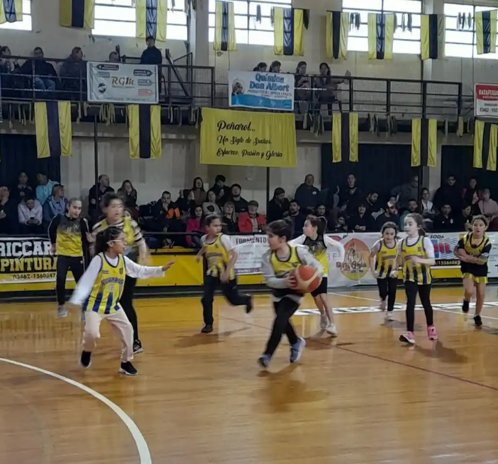 Las niñas en pleno partido de básquet camino al aro.