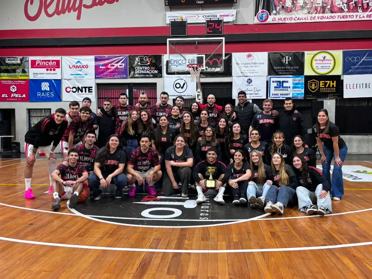 Los planteles de primera, masculino y femenino, posando con la copa lograda por las chicas. Primera vez en la historia que el mismo club es campeón de ambas categorías al mismo tiempo. Foto: Fabián Gallego.