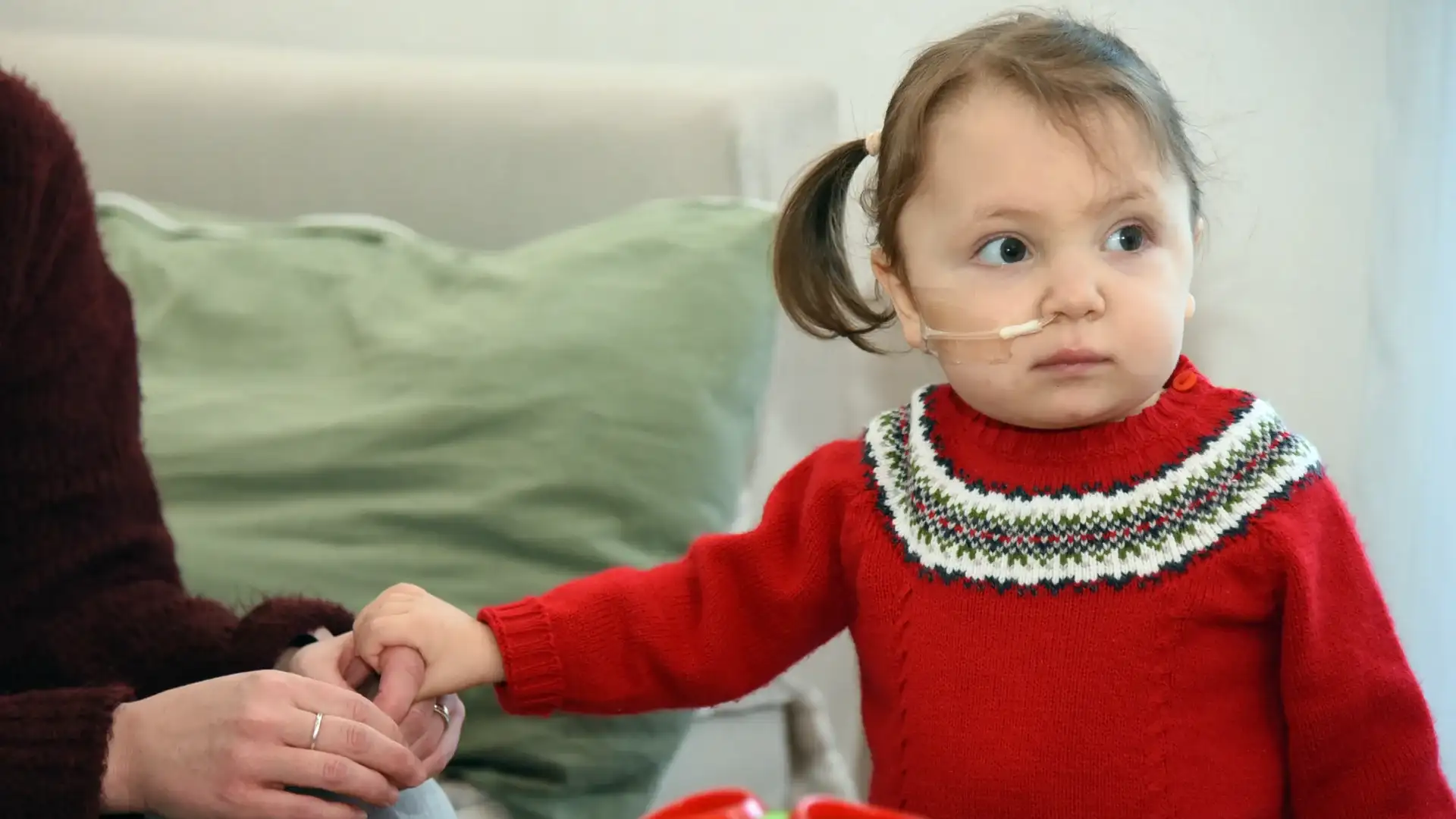 Inés Socobehere, la pequeña tandilense que recibió un trasplante de corazón, sostiene la mano de su madre Julia Fuentes.
