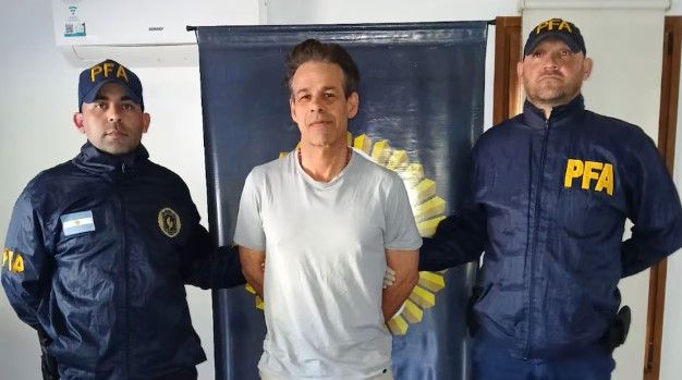 Machado sonríe tras ser esposado por la PFA