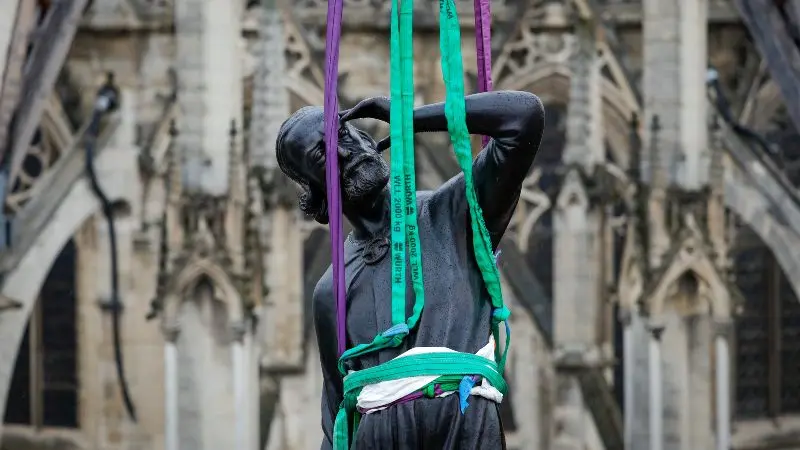 Una grúa eleva una estatua de Santo Tomás, la última de las 16 estatuas gigantes de apóstoles revestidas de cobre en colocarse. / Foto Por AFP