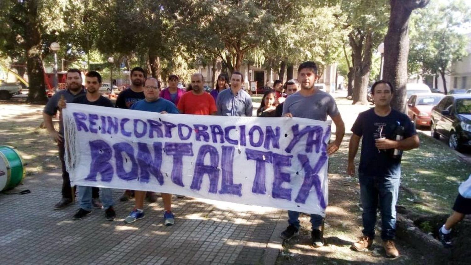 Silva sostiene la bandera junto al resto de los despedidos frente a la Municipalidad 