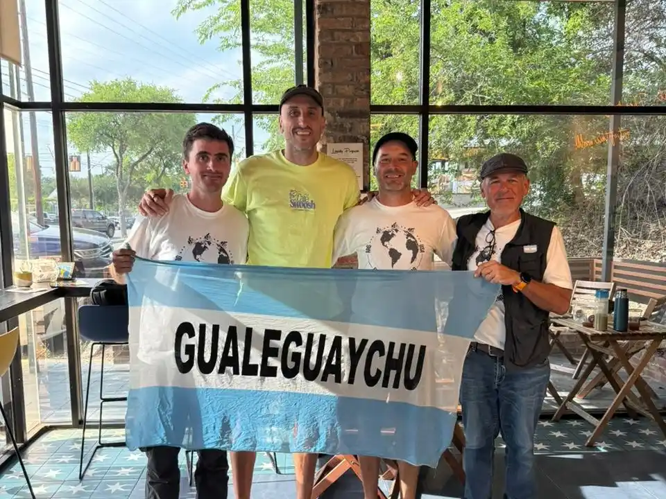 Vicente, Manu, Yamandú y Miguel posan con la bandera argentina y la insignia de Gualeguaychú