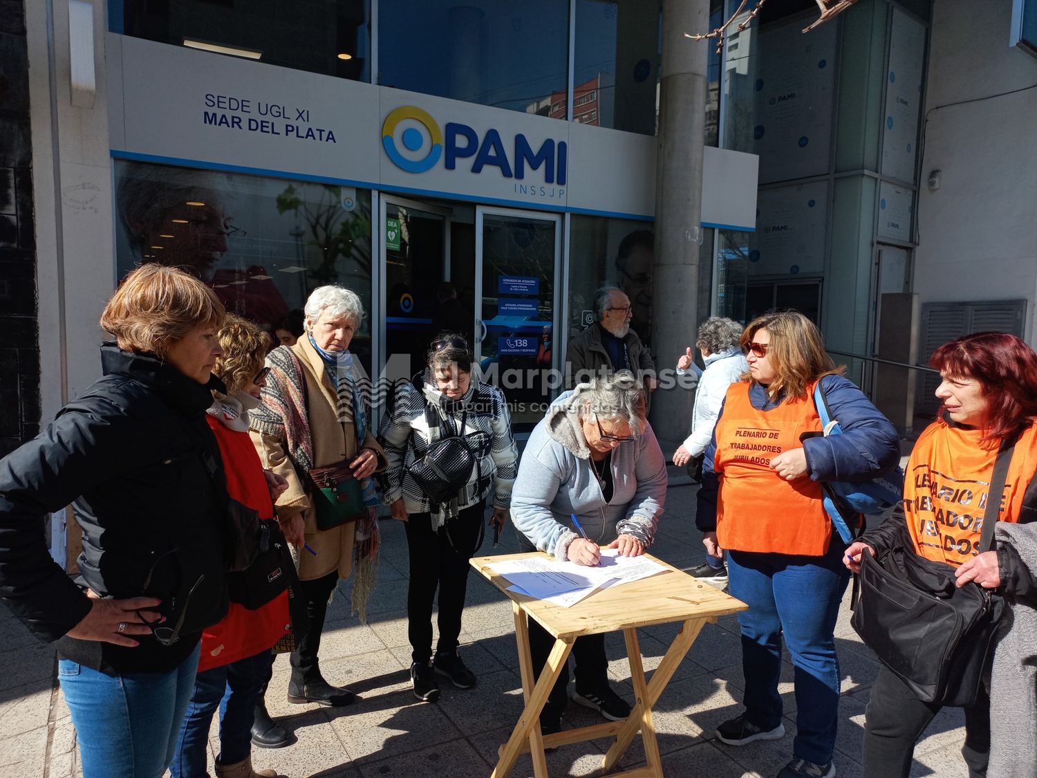 Jubilados juntan firmas frente a la puerta del PAMI para frenar las medidas impulsadas por el gobierno nacional.